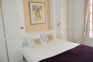 a bedroom with a white bed with two pillows at Villa les Faou-Anis in Le Castellet