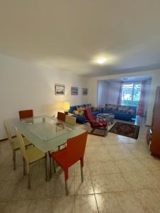 una sala de estar con una mesa, sillas y un sofá en Apartman Luka5, en Petrovac na Moru