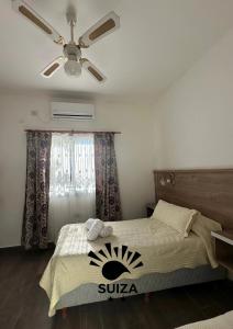 Hotel Suiza في ترماس دي ريو هوندو: غرفة نوم بها سرير ومروحة سقف