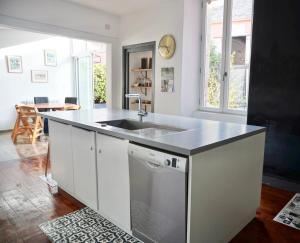 a kitchen with a sink and a counter top at Grande maison centre ville in Laval +26 photos