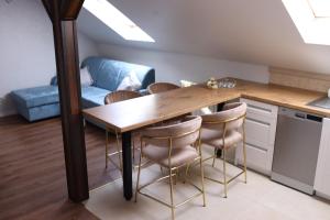 a kitchen with a wooden table and chairs at Apartament na poddaszu in Sandomierz