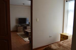 a room with a bedroom with a television and a mirror at Departamento entero soleado in Sucre