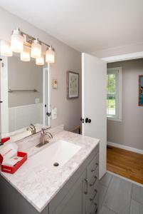 a white bathroom with a sink and a mirror at Cape Cod Cottage by Leavetown Vacations in Dennis Port