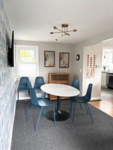 a dining room with a white table and blue chairs at Cape Cod Cottage by Leavetown Vacations in Dennis Port