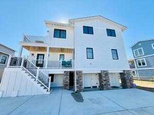 a white house with a staircase in front of it at Sea side drive 8 in Bethany Beach