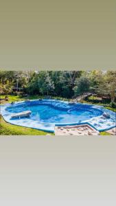 a large swimming pool with blue water in a park at Cabañas la Granja Rincón de Guayabitos in Rincon de Guayabitos