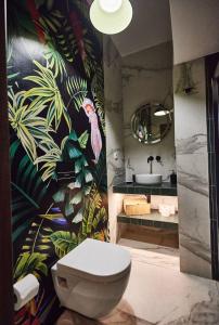 a bathroom with a toilet and a tropical wallpaper at Bari in Acropolis in Athens