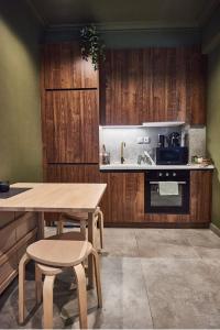 a kitchen with wooden cabinets and a wooden table and chairs at Bari in Acropolis in Athens