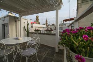 a balcony with a table and chairs and flowers at Casa Chiasso Cacace in Monopoli