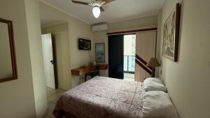 a bedroom with a large bed and a window at Flat Capitania Varam l beira-mar l 2 vagas l Serv Praia in Guarujá +28 photos