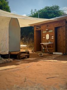 a building with a tent and a table in front of it at חוות רפאל in Mashabbe Sade