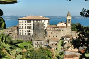 a group of buildings on a hill with a clock tower at Il Piccolo Fienile in Gradoli