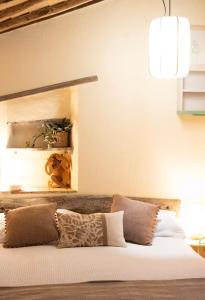 a bedroom with a bed with white sheets and pillows at Il Piccolo Fienile in Gradoli +25 photos