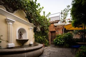une fontaine dans la cour d'un bâtiment dans l'établissement Hotel La Villa Serena, à Antigua Guatemala