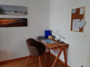 a desk with a chair next to a wall at Ferienwohnung Central in Rostock