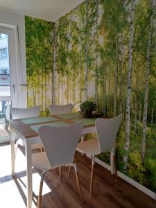 a dining room with a wall mural of aspen trees at Ferienwohnung Central in Rostock