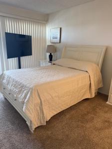 ein Schlafzimmer mit einem Bett und einem Flachbildfernseher in der Unterkunft Two Bedroom Condo in Huntington Beach in Huntington Beach
