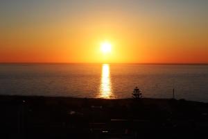a sunset over the ocean with the sun setting at Appartamenti da Clarissa in Macari