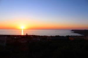 a sunset over the ocean with the sun setting at Appartamenti da Clarissa in Macari