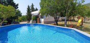 a large blue swimming pool in front of a house at Villa Bonaluz in Starigrad