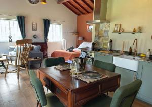 a kitchen and living room with a table and chairs at The Cão & Calf in Faja Grande