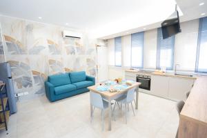 a kitchen with a table and a blue couch at Casa Giardina in Catania