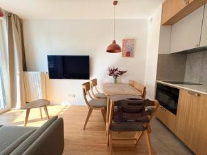 a kitchen and dining room with a table and chairs at Len Apartments One Gdańsk Sobieszewo Baltic Line blisko morza na Wyspie Sobieszewskiej dla rodzin przyjazny zwierzętom z tarasem in Gdańsk