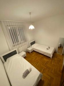 Dos camas en una habitación con suelo de madera. en Apartment X, en Pristina 6 fotos más