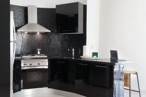 a black kitchen with a stove and a sink at Armonia 24 suites by Yellowkey in Los Prados +269 photos
