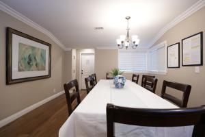 a dining room with a white table and chairs at Upscale 6 Bed, 5 Ba, New Pool W/Jacuzzi, 1/2 Mile Walk to Disney in Anaheim