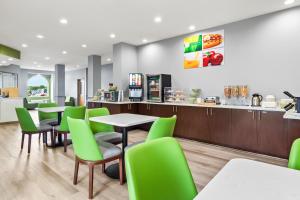 a restaurant with tables and green chairs at Quality Inn Shallotte near Ocean Isle Beach in Shallotte
