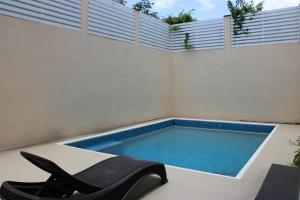 una piscina sul lato di un edificio con una sedia di Terry's House a Cozumel