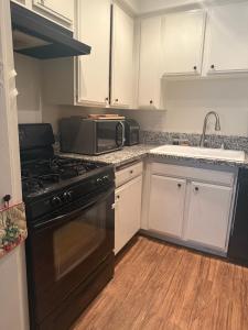 eine Küche mit einem schwarzen Herd und einer Mikrowelle in der Unterkunft Two Bedroom Condo in Huntington Beach in Huntington Beach