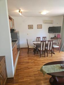 a kitchen and dining room with a table and chairs at Apartman Elena Budva in Budva +8 photos