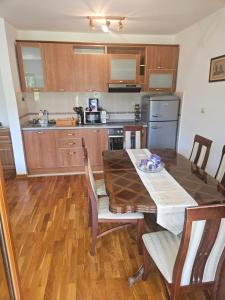 a kitchen with a wooden table and a dining room at Apartman Elena Budva in Budva