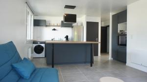 a kitchen with a blue couch and a kitchen island at Chez Lulu, au pied de la Dolce Via in La Voulte-sur-Rhône +3 photos