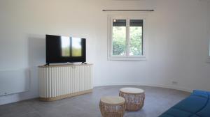 a living room with a tv and two stools at Chez Lulu, au pied de la Dolce Via in La Voulte-sur-Rhône