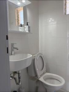a white bathroom with a toilet and a sink at VK Beach House in Kalives Poligirou +20 photos