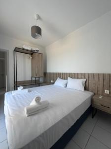 a bedroom with a large bed with two towels on it at VK Beach House in Kalives Poligirou