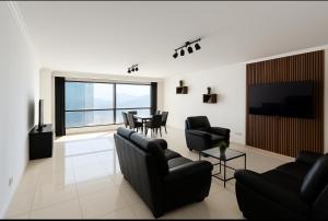 奥兰Mobilart Oran Sur Vue Mer的客厅配有黑色家具和电视