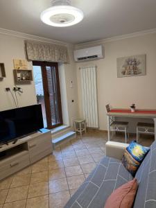 a living room with a couch and a tv and a table at Dimora Charme in Monterotondo