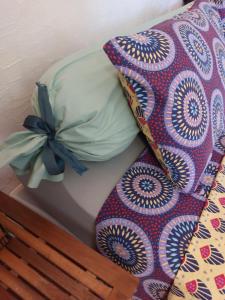 a bed with a comforter and a pillow with a bow at La Campagne de Lili - Chambre et Cuisine sur Terrasse privée in Ongles