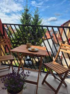 ein Holztisch und zwei Stühle auf einem Balkon in der Unterkunft Apartament Morska Harmonia in Ustka