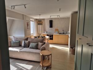 ein Wohnzimmer mit Sofa und eine Küche in der Unterkunft Apartament Morska Harmonia in Ustka