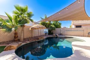 a swimming pool in a yard with an umbrella at Harrison Chandler in Chandler