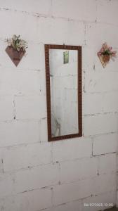 a mirror hanging on a white brick wall at Sítio Conquista Feliz in Nova Iguaçu