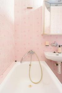 - une salle de bains rose avec baignoire et lavabo dans l'établissement Team Flat & Urban Family Comfort - HomeBase with a Castle view, à Petržalka 96 autres photos