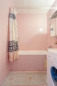 - une salle de bains rose avec baignoire et lavabo dans l'établissement Team Flat & Urban Family Comfort - HomeBase with a Castle view, à Petržalka