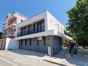 a white building with a balcony on a street at Rosiem Boutique in Techirghiol