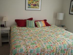 a bedroom with a bed with a colorful comforter and pillows at Rolling road 3 in Rehoboth Beach